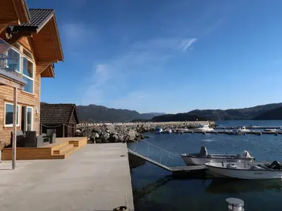 two boats are docked in a marina next to a house at Apartment Huglavika by Interhome in Nordhuglo