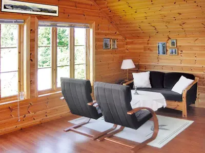 a living room with a couch and a table and chairs at Chalet Hardangerrorbu by Interhome in Tjoflot