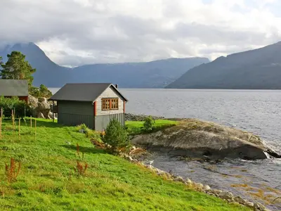 a small house on the shore of a body of water at Chalet Hardangerrorbu by Interhome in Tjoflot