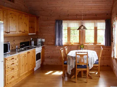 a kitchen with a table and chairs in a cabin at Chalet Eiknes by Interhome in Tjoflot
