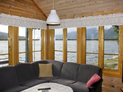a living room with a couch and a view of the water at Chalet Eiknes by Interhome in Tjoflot