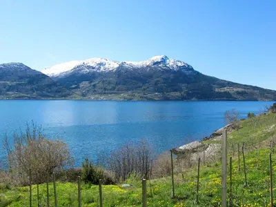 a view of a lake with snow covered mountains at Chalet Slåttenes by Interhome in Naustflot