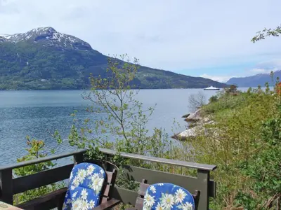 two blue and white chairs sitting next to a body of water at Chalet Slåttenes by Interhome in Naustflot