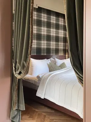 a bedroom with a hanging bed with green curtains at Hotel Union Øye in Øye