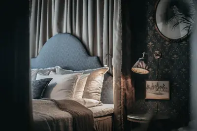 a bedroom with a bed with a blue head board at Hotel Union Øye in Øye