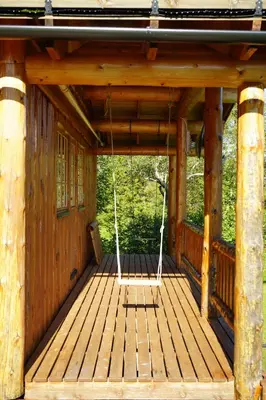 a porch of a wooden cabin with a porch swing at Langlofonna in Stranda