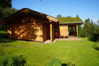 a small cabin with a grass roof in a yard at Langlofonna in Stranda