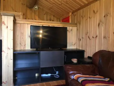 a living room with a couch and a flat screen tv at Nilsrud 30 Feriehus in Åmotsdal