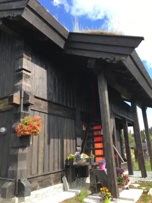 a wooden building with flowers on the side of it at Nilsrud 30 Feriehus in Åmotsdal