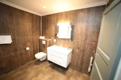 a bathroom with a white sink and a toilet at Villa Oleanna in Lysekloster
