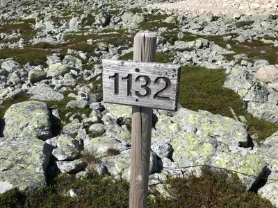 a sign on top of a pile of rocks at Lillebjørn in Trysil