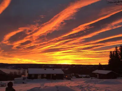 a sunset over a house in the snow at Cabin with great view close to town and ski area in Lillehammer