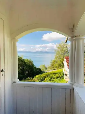 a window in a house with a view of the ocean at Moldegaard Farmhouse - Apartment B in Moldegard