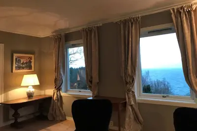 a room with two windows and a desk and a lamp at Moldegaard Farmhouse - Apartment B in Moldegard