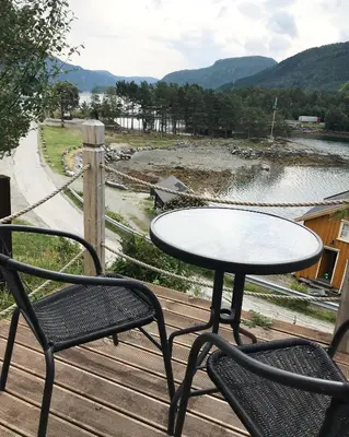 a table and two chairs sitting on a wooden deck at Valsøya in Valsøyfjord