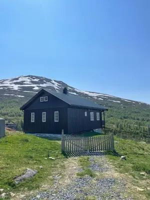 a black house on the side of a hill at Bjørgo Gard - Stegastein in Aurland