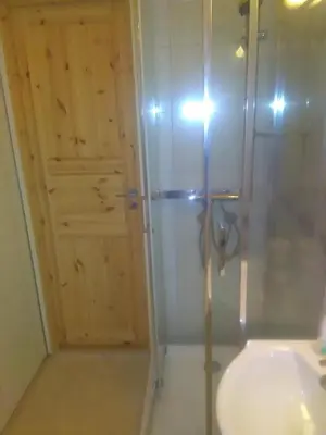 a bathroom with a shower and a sink and a door at Bjørgo Gard - Stegastein in Aurland
