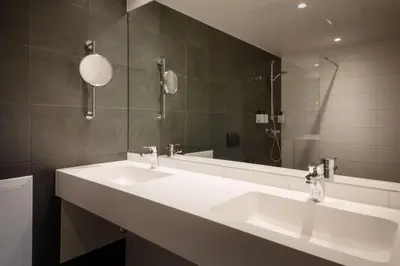 a bathroom with two sinks and a large mirror at Scandic Voss in Vossevangen