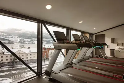 a gym with three treadmills and a large window at Scandic Voss in Vossevangen