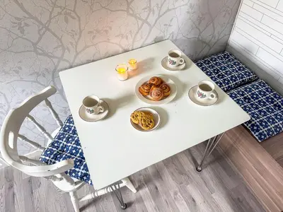 a white table with cups of coffee and pastries on it at Holiday Home Rødehuset by Interhome in Gjelland