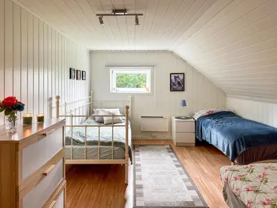 a small bedroom with a bed and a window at Holiday Home Rødehuset by Interhome in Gjelland