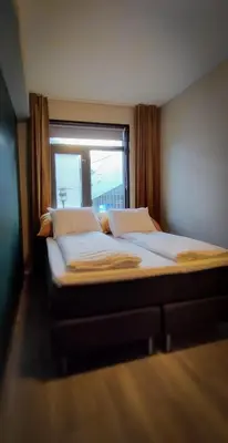 a large bed in a room with a window at Hotell Molde in Molde