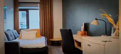 a room with a desk and a chair and a table at Hotell Molde in Molde