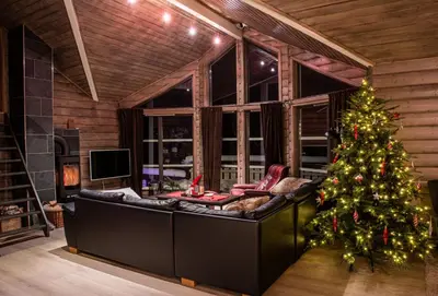 a living room with a christmas tree and a couch at Cabin in Hodlekve with 5 bedrooms & hot tub. in Sogndal