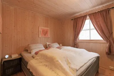 a bedroom with a bed and a window at Cabin in Hodlekve with 5 bedrooms & hot tub. in Sogndal