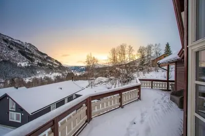 a balcony of a house in the snow at Cabin in Hodlekve with 5 bedrooms & hot tub. in Sogndal