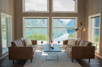 a living room with two couches and a table at Furetoppen Panorama in Stryn