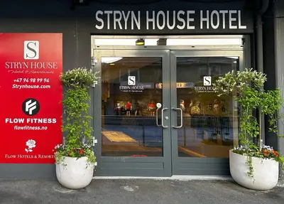 a store front with two potted plants in front of the door at Stryn House Hotel in Stryn