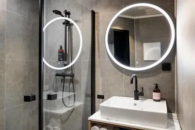 a bathroom with a sink and a shower with a mirror at Stryn House Hotel in Stryn