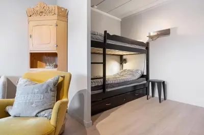 a room with two bunk beds and a chair at Spåtind Fjellhotell in Nord Torpa