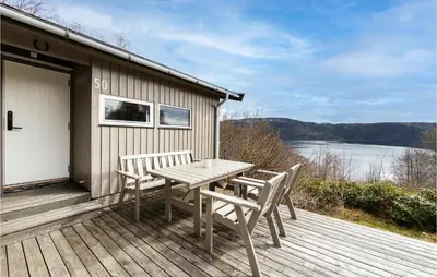 a wooden deck with a table and two chairs at Awesome Home In Vatne With Wifi in Vatne