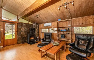 a living room with a table and chairs and a fireplace at Awesome Home In Vatne With Wifi in Vatne