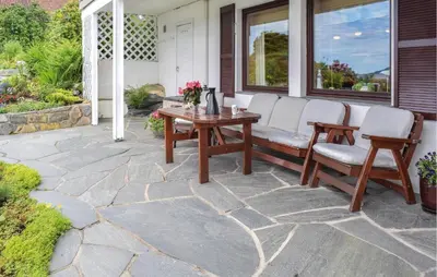 a patio with a wooden table and chairs at 1 Bedroom Lovely Apartment In Svortevik in Svortevik