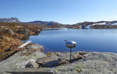 a lake with a bird sitting on a rock at 1 Bedroom Lovely Apartment In Svortevik in Svortevik