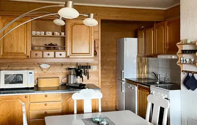 a kitchen with wooden cabinets and a white refrigerator at 1 Bedroom Lovely Apartment In Svortevik in Svortevik