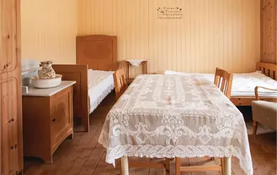a bedroom with two beds and a table and chairs at Beautiful Home In Tynset With Kitchen in Tynset