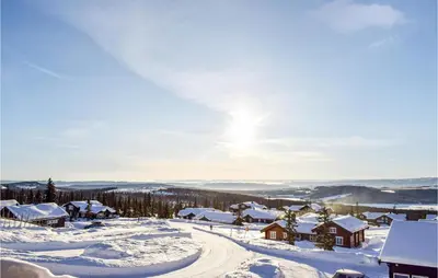 a village covered in snow with the sun in the sky at Gorgeous Home In Sjusjøen With Wifi in Sjusjøen
