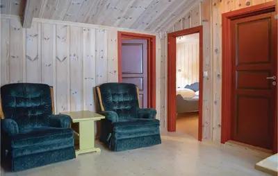 two chairs and a table in a room with wooden walls at Nice Home In Gol With Kitchen in Gol