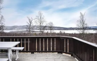 a deck with a picnic table and a view of a lake at Stunning Home In Hemsedal With Kitchen in Hemsedal
