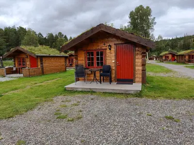 a small cabin with a table and chairs in the yard at Halland Camping in Berkåk