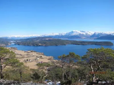 a view of a lake with mountains in the background at Presthus Gård in Ølve