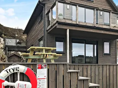 a house with a bench on the side of it at 8 person holiday home in Urangsvåg in Ervik