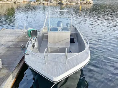 a boat is docked at a dock on the water at 8 person holiday home in Urangsvåg in Ervik