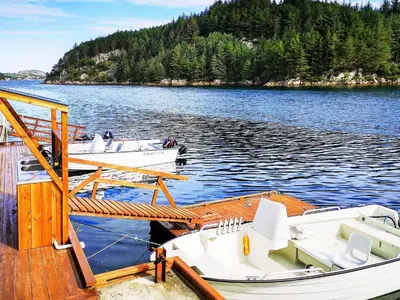 three boats are docked at a dock on a lake at Seaside Fisherman s Haven-By Traum in Steinsbø