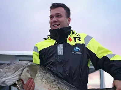 a man holding a fish in his hands at Seaside Fisherman s Haven-By Traum in Steinsbø