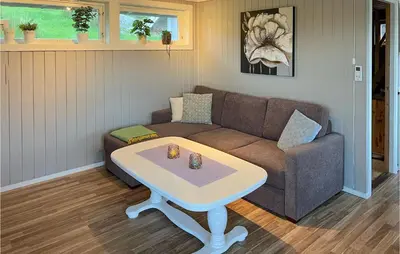 a living room with a couch and a coffee table at 2 Bedroom Cozy Home In Hauglandshella in Kolavåg